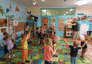 Dzieci tańczą z kolorową bibułą.