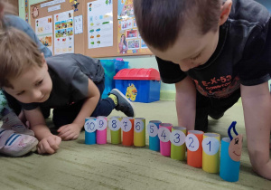 Dzieci układają gąsiennicę według cyfr.