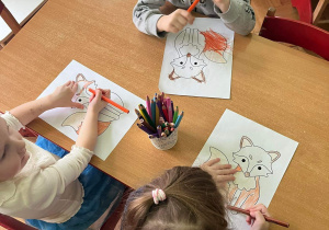 Dzieci kolorują rysunek lisa.