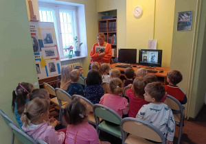Dzieci oglądają bajkę w bibliotece.