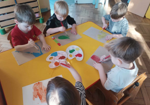 Dzieci malują łyżwy farbami.