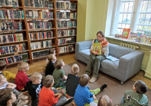 Dzieci słuchają opowiadania czytanego przez Panią z Biblioteki