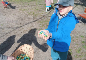 Dzieci zbierają jajka czekoladowe w ogrodzie .